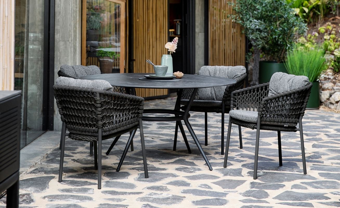 Ocean Outdoor Dining Chair in Dark Grey with the Natté Grey Optional Cushion Set at a table - Danish Design Co Singapore