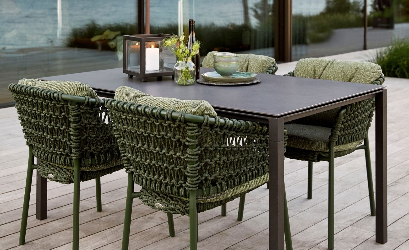 Ocean Outdoor Dining Chair in Dark Green at a table - Danish Design Co Singapore