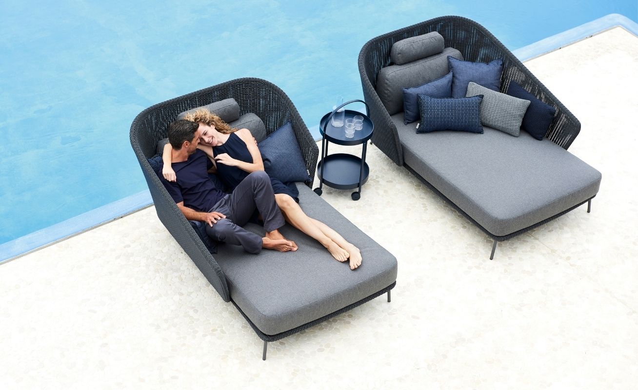 Cane-line Mega Outdoor Daybed in Dark Grey with Light Grey Cushions by a pool - Danish Design Co Singapore