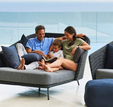 Cane-line Mega Outdoor Daybed in Dark Grey with Light Grey Cushions with family in it - Danish Design Co Singapore